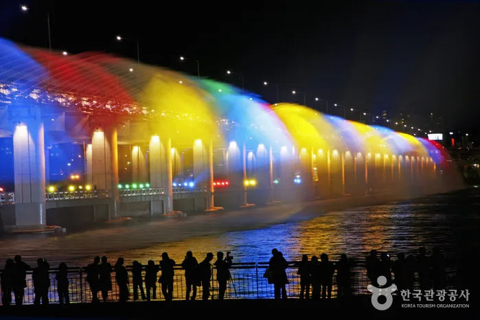 漢江の盤浦大橋で月光レインボー噴水が虹色にライトアップされた夜景写真（出典：韓国観光公社）