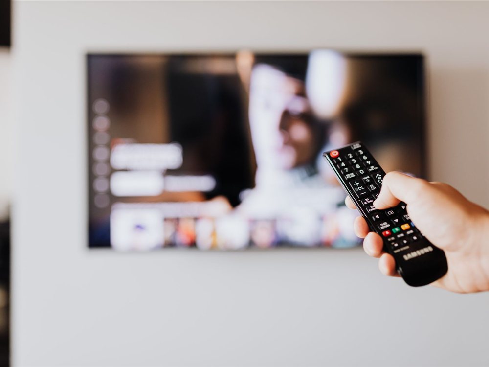 BTSのテレビ放送スケジュールを自宅リビングでチェックしながらCS放送を視聴するイメージ